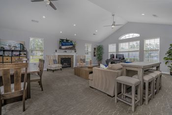 A spacious living room with a fireplace and a dining table set up.